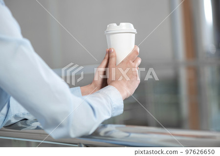 close-up of women's hands with a cup of coffee 97626650
