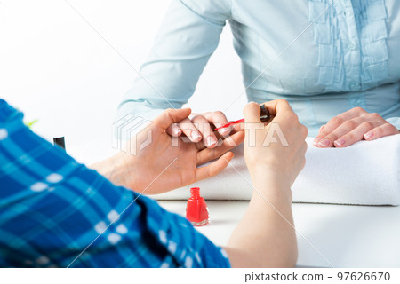 Manicurist working with client's nails at table Manicurist working with client's nails at table 97626670