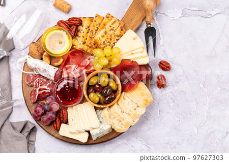 Antipasto board with prosciutto, salami, crackers, cheese Antipasto board with prosciutto, salami, crackers, cheese 97627303