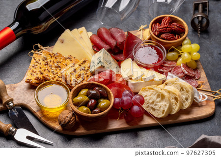 Antipasto board with prosciutto, salami, crackers, cheese Antipasto board with prosciutto, salami, crackers, cheese 97627305