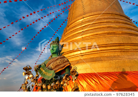 Thai angel by golden stupa in sunlight and blue sky in Buddhist temple. Thai angel by golden stupa in sunlight and blue sky in Buddhist temple. 97628345