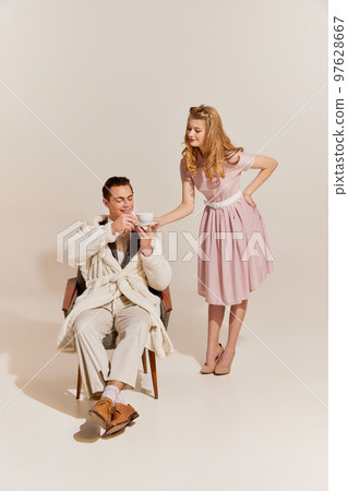 Family values, support and care. Portrait of family couple in retro style clothes isolated over light background. Concept of love, relationship, retro style, creativity, hobbies. Family values, support and care. Portrait of family couple in retro style clothes isolated over light background. Concept of love, relationship, retro style, creativity, hobbies. 97628667