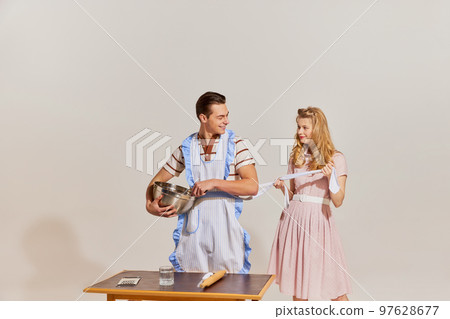 Family values. Portrait of family couple in retro style clothes isolated over light background. Concept of love, relationship, retro style, creativity, hobbies. 97628677