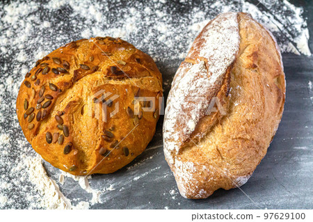 Bakery background with baked bread on flour table Bakery background with baked bread on flour table 97629100