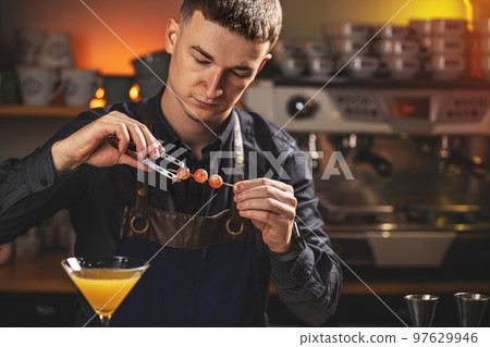 Barman adding decor elements 97629946
