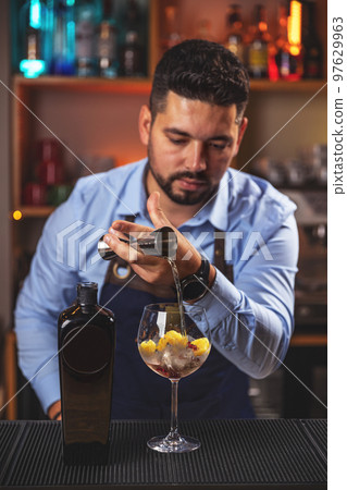 Barman gently pours drink 97629963