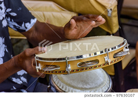 Hands and instrument of musician playing tambourine in Salvador Hands and instrument of musician playing tambourine in Salvador 97630107