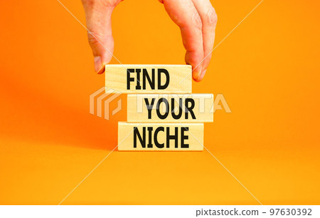 Find your niche symbol. Concept words Find your niche on wooden blocks. Businessman hand. Beautiful orange table orange background. Business and find your niche concept. Copy space. 97630392