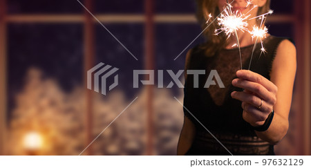 woman holding sparkles Christmas or New Year woman holding sparkles Christmas or New Year 97632129