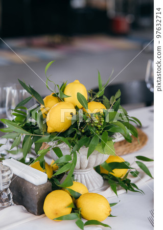 Festive table decorated with lemon arrangements Festive table decorated with lemon arrangements 97632714