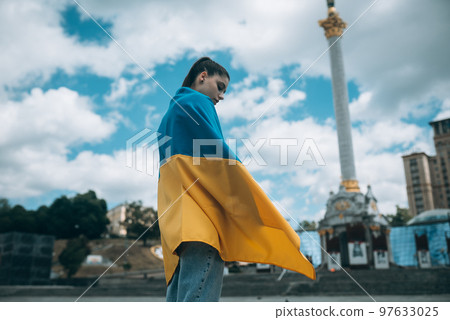 Young woman covered with the Ukrainian flag 97633025