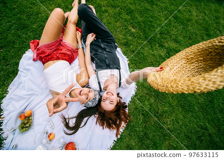 Top view, two young women lying in the park Top view, two young women lying in the park 97633115