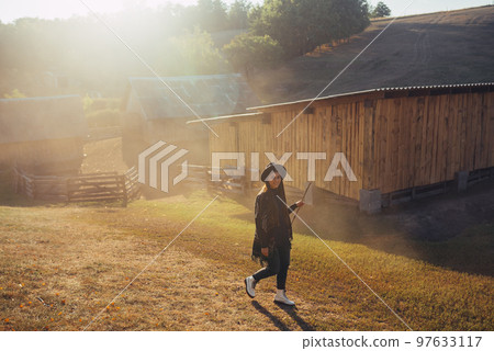 Beautiful young girl in a rustic style in the countryside on a farm Beautiful young girl in a rustic style in the countryside on a farm 97633117