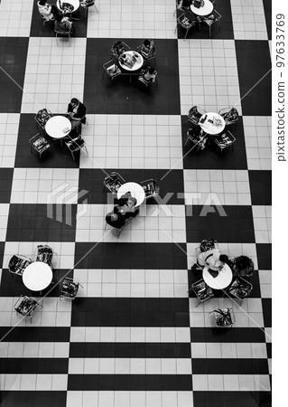 從購物中心的咖啡館的較高樓層拍攝。規則排列的桌子和地板之間的對比 97633769