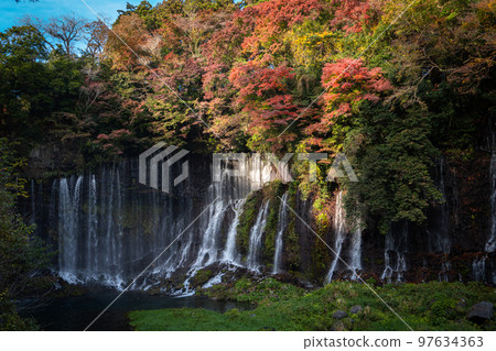 Autumn colors make the waterfalls in the forest Japan 97634363
