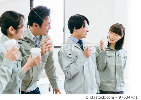 工廠、建築車間等中小企業休息時穿著工作服喝咖啡聊天的員工側面照 97634471