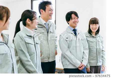 Side profile of employees and staff wearing work clothes working in small and medium-sized enterprises such as factories and construction shops (businessmen and businesswomen) 97634475
