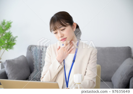 A woman with a sore throat at work A woman with a sore throat at work 97635649