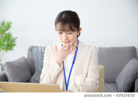 A woman with a sore throat at work A woman with a sore throat at work 97635650