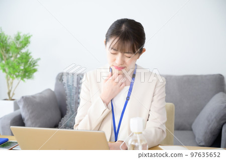 A woman with a sore throat at work A woman with a sore throat at work 97635652
