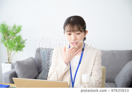 A woman with a sore throat at work A woman with a sore throat at work 97635653