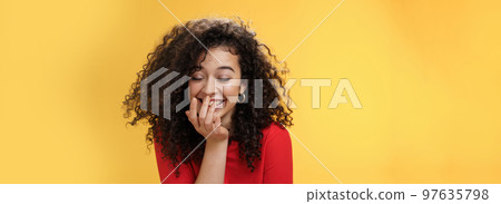 Girl laughing out loud cannot hold laugh as feeling amused hearing hilarious jokes covering mouth with palm as chuckling happily tilting forward with closed eyes, smiling over yellow wall Girl laughing out loud cannot hold laugh as feeling amused hearing hilarious jokes covering mouth with palm as chuckling happily tilting forward with closed eyes, smiling over yellow wall 97635798