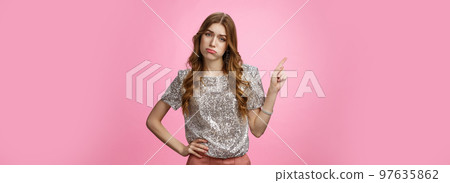 Party sucks boring. Indifferent arrogant snobbish rich glamour young girl sighing sulking displeased disappointed look camra pointing upper left corner unimpressed bored, standing pink background Party sucks boring. Indifferent arrogant snobbish rich glamour young girl sighing sulking displeased disappointed look camra pointing upper left corner unimpressed bored, standing pink background 97635862