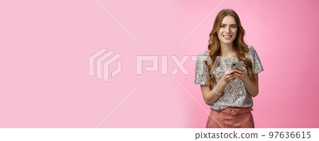 Sociable friendly-looking stylish attractive european young 20s woman dress-up party call friends use taxi application smiling joyfully standing positive carefree, messaging hold smartphone 97636615