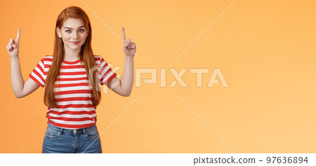 Cute lovely redhead girlfriend hint boyfriend what buy anniversary, pointing copy space promo, indicate fingers up, look camera assured, determined get what want, stand orange background 97636894
