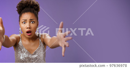 Close-up excited african woman in stylish fashionable silver glittering dress extend arms fowards frowning gasping look concerned worry friend fall standing concerned rushing help, blue background 97636978