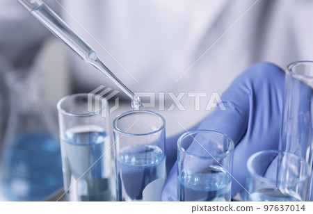 Researcher with glass laboratory chemical test tubes with liquid for analytical , medical, pharmaceutical and scientific research concept. 97637014
