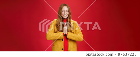 Girl welcomes us with buddhist namaste gesture pressing palms together over chest smiling friendly and delighted with carefree emotions holding hands in pray, posing happily over red background Girl welcomes us with buddhist namaste gesture pressing palms together over chest smiling friendly and delighted with carefree emotions holding hands in pray, posing happily over red background 97637223