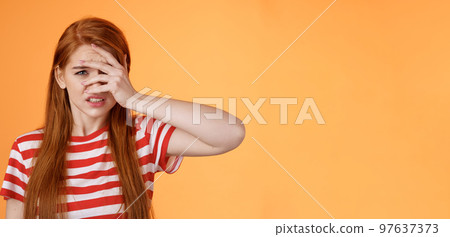 Uneasy redhead girl pity for bad situation, trying not look awful friend wound, cringe aversion, dislike watch horror stories, feel disgust upset, standing uncomfortable clench teeth dislike 97637373