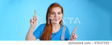 Close-up cheerful carefree redhead dancing girl pointing up, raising fingers, smiling amused, having fun, stand blue background entertained, enjoy music party, disco mood, carefree emotions concept Close-up cheerful carefree redhead dancing girl pointing up, raising fingers, smiling amused, having fun, stand blue background entertained, enjoy music party, disco mood, carefree emotions concept 97637395