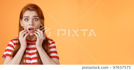 Scared shocked redhead woman worry, stare camera speechless gasping concerned, touch lips drop jaw astonished, hear terrifying scary news, stand orange background stupor, very upset Scared shocked redhead woman worry, stare camera speechless gasping concerned, touch lips drop jaw astonished, hear terrifying scary news, stand orange background stupor, very upset 97637575