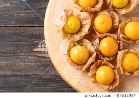 Cape gooseberry or golden berry (Physalis peruviana) on wooden board with copy space 97638084