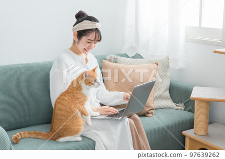A woman who telework/remote work with a cat at home 97639262