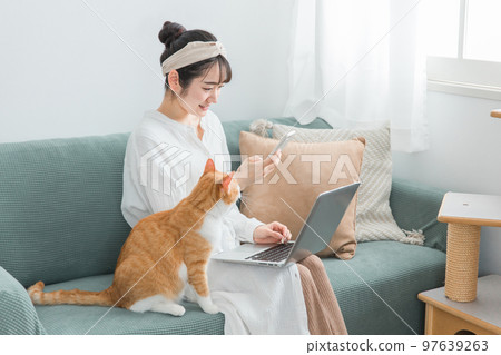 在家帶貓遠程工作/遠程工作的女性（電腦/智能手機） 97639263