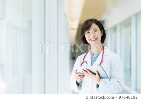 Female doctor using a tablet device Female doctor using a tablet device 97640182