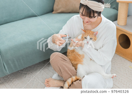 剪貓指甲的主人的亞洲女人 97640326