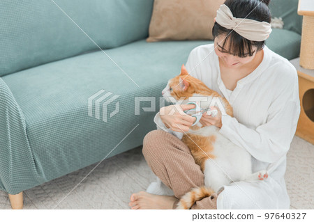 Asian woman of the owner who cuts the nail of the cat 97640327