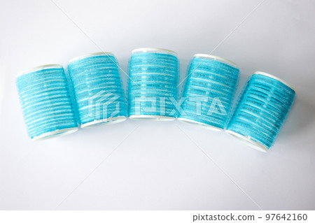 Blue curlers with sticky tape for beautiful curls on a white background. Blue curlers with sticky tape for beautiful curls on a white background. 97642160