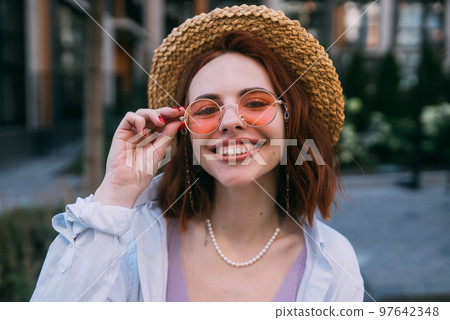 Young woman with toothy smile in outdoors Young woman with toothy smile in outdoors 97642348