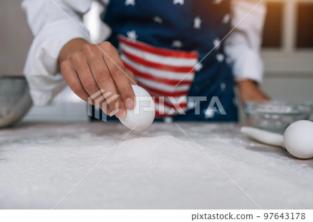 Girl confectioner holding chicken egg in her hand 97643178