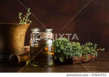 Bottle of thyme essential oil with fresh thyme. Bottle of thyme essential oil with fresh thyme. 97643755