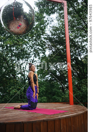 Sporty woman performs kneeling exercises while standing on a mat 97643985