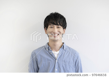 A young man looking at the camera and smiling 97646638