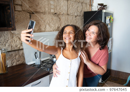 Multiracial family taking a selfie in the kitchen of their home Multiracial family taking a selfie in the kitchen of their home 97647045