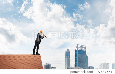 Engineer man standing on roof and looking in spyglass. Mixed media Engineer man standing on roof and looking in spyglass. Mixed media 97647364