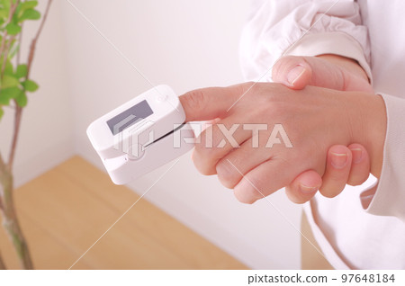 Woman measuring blood oxygen 97648184
